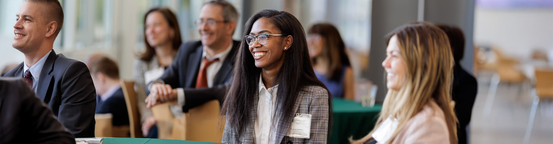 Law students dressed in professional attire sitting and smiling.