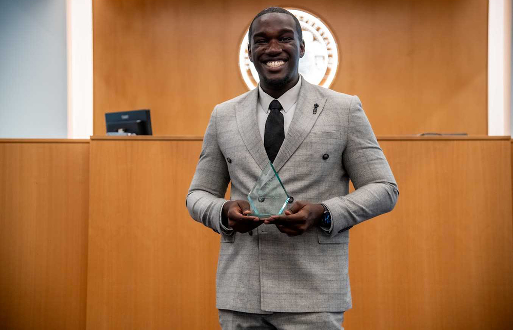 A man standing in business attire smiling